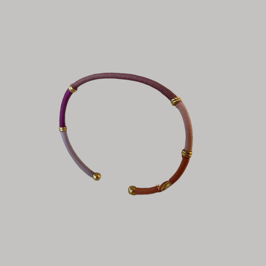 coloured threaded bracelet on light grey background