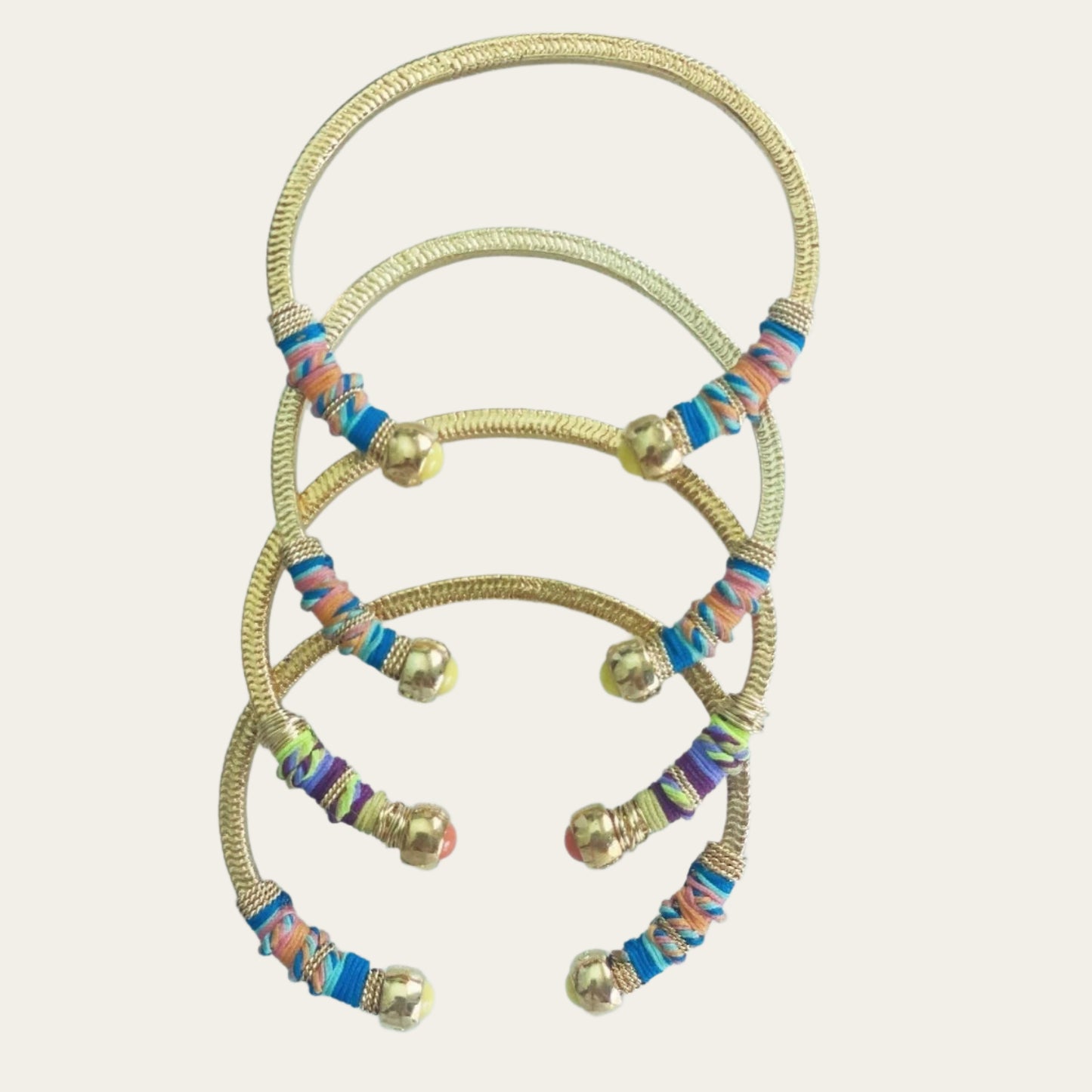 Gold plated bracelets embellished with tinted threads and gold plated chains. The bracelet is adorned with glass beads at ends. Adjustable size. Product Details Yellow Gold Plated Cotton Rope or all metal Width: 0,6 cm; Circumference: 14,5 cm
