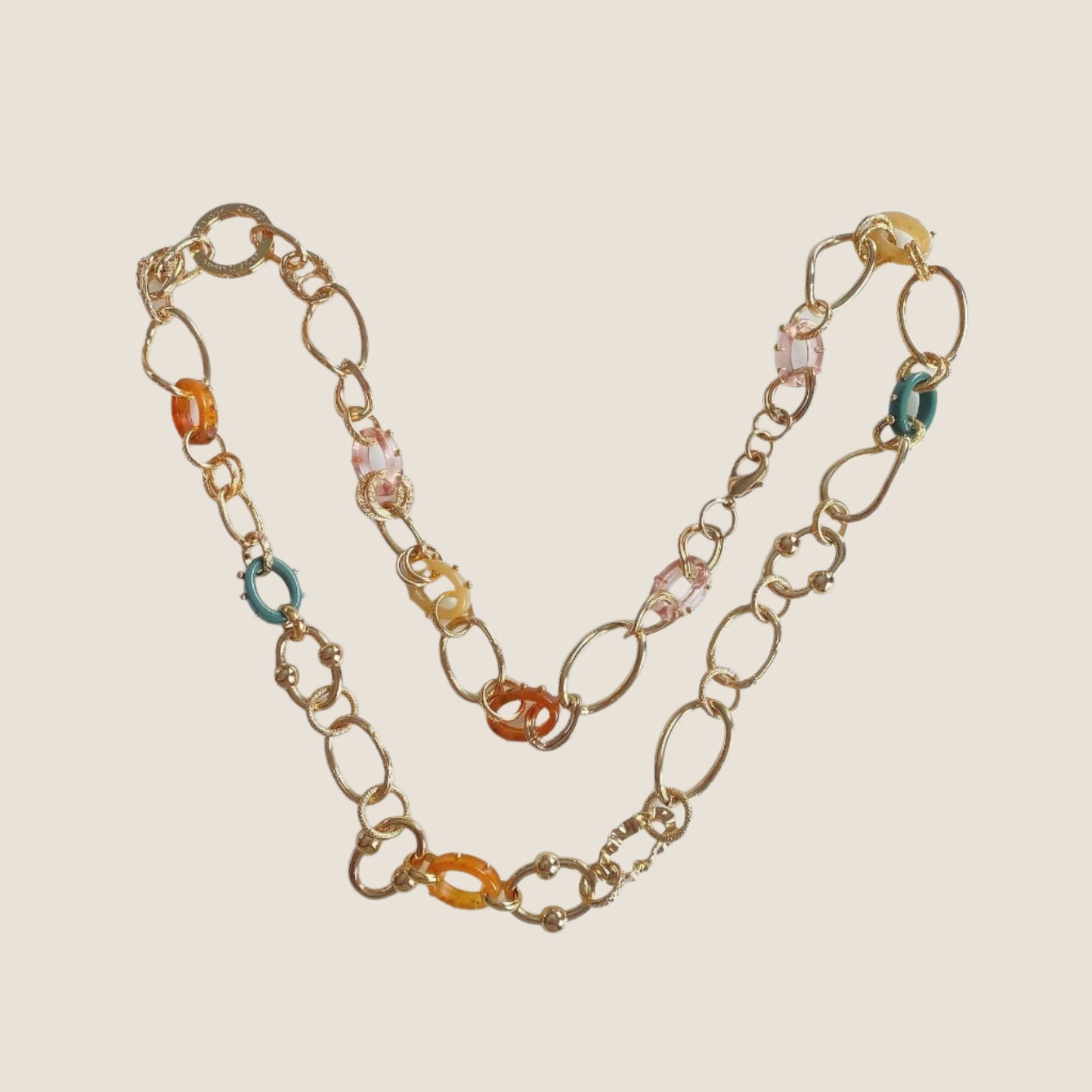 Gold plated chain link necklace on flat lay with coloured acetate links in between