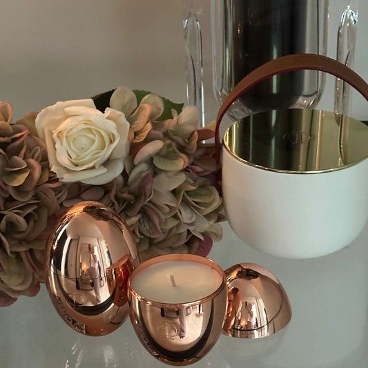 omorfi rose gold candles amongst flowers and ceramic candle