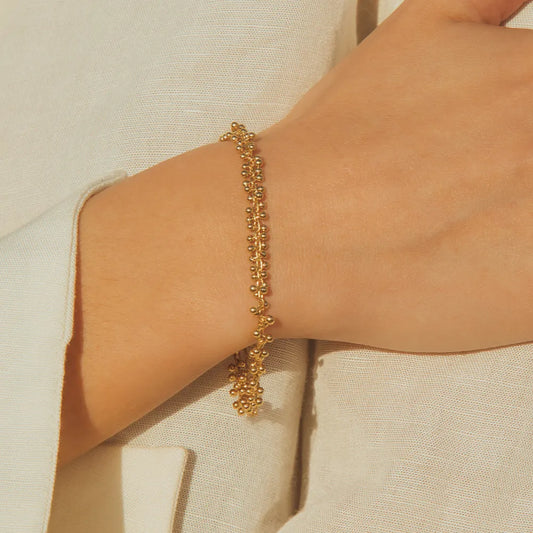 Achille Agape bracelet on models hand with neutral background available at The Artemis Edit