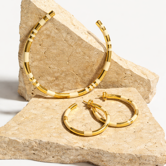 gold and white hoops on travertine background