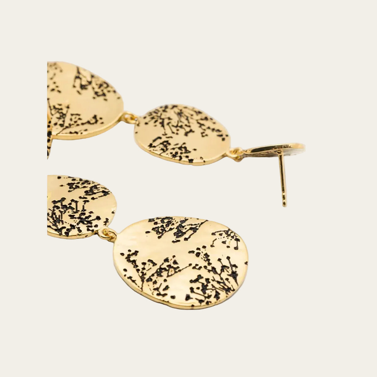 Close-up of Hermione gold-plated earrings, showing floral detailing and linked tiers.