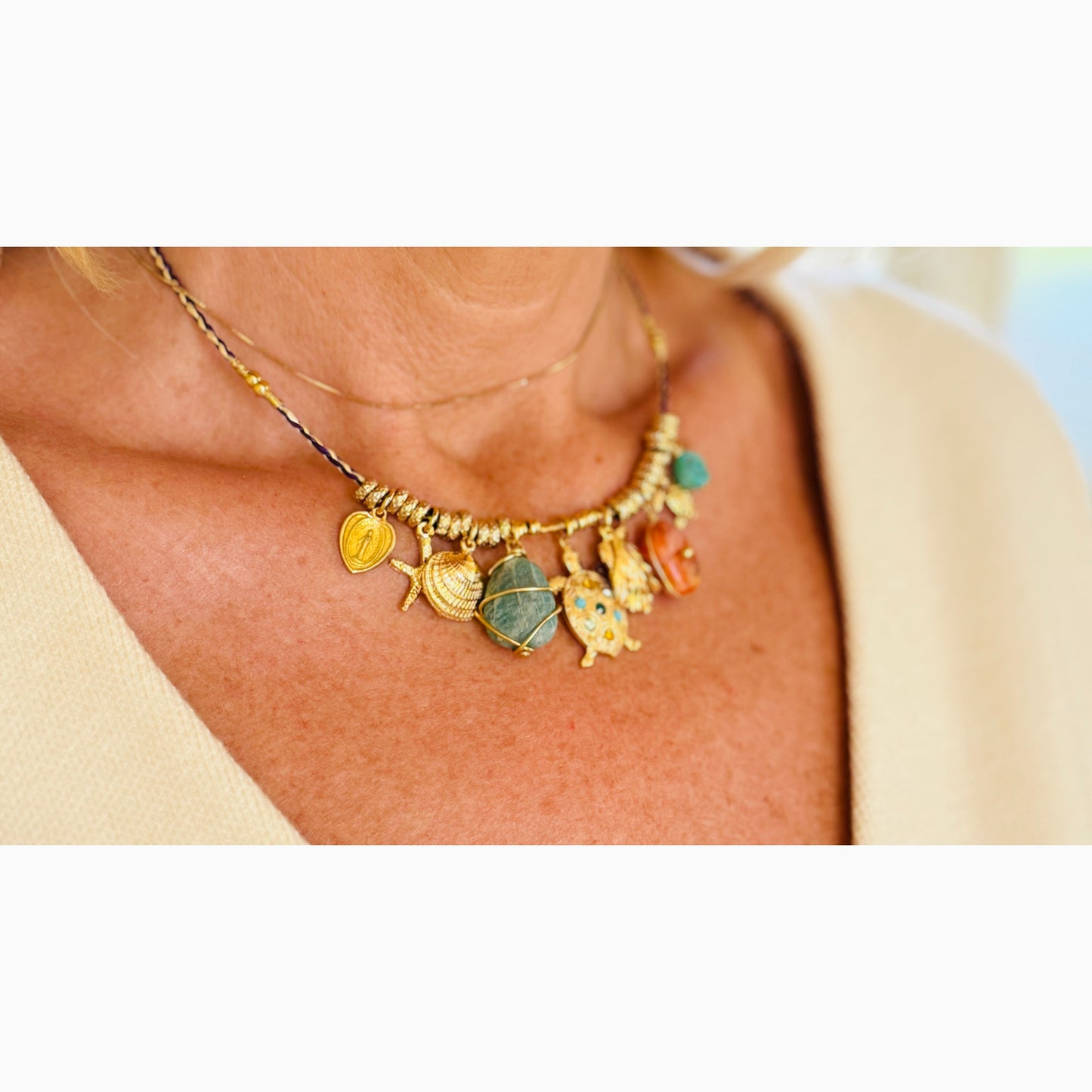 Necklace with various charms worn by a person