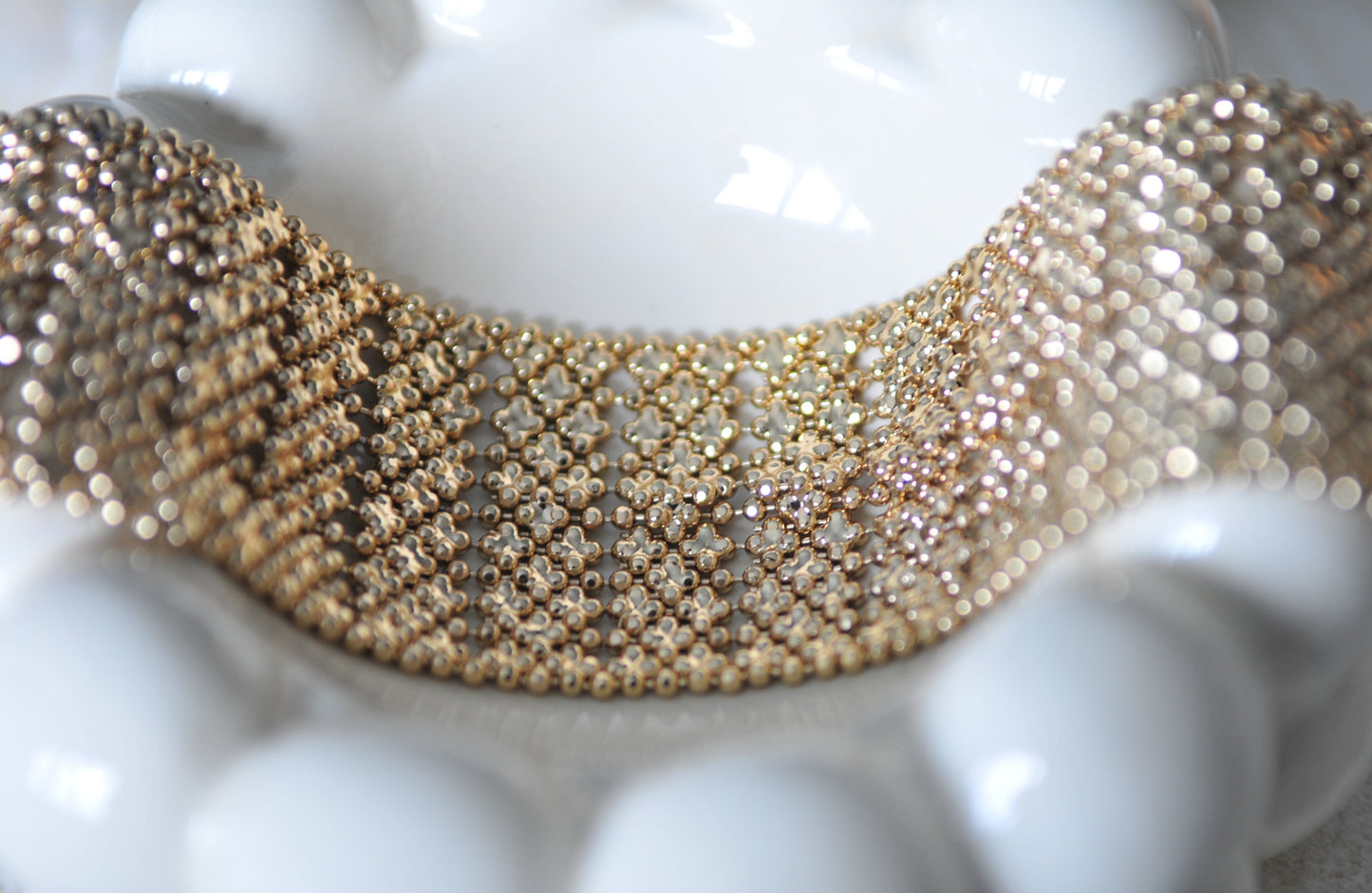Gold beaded bracelet on a white surface
