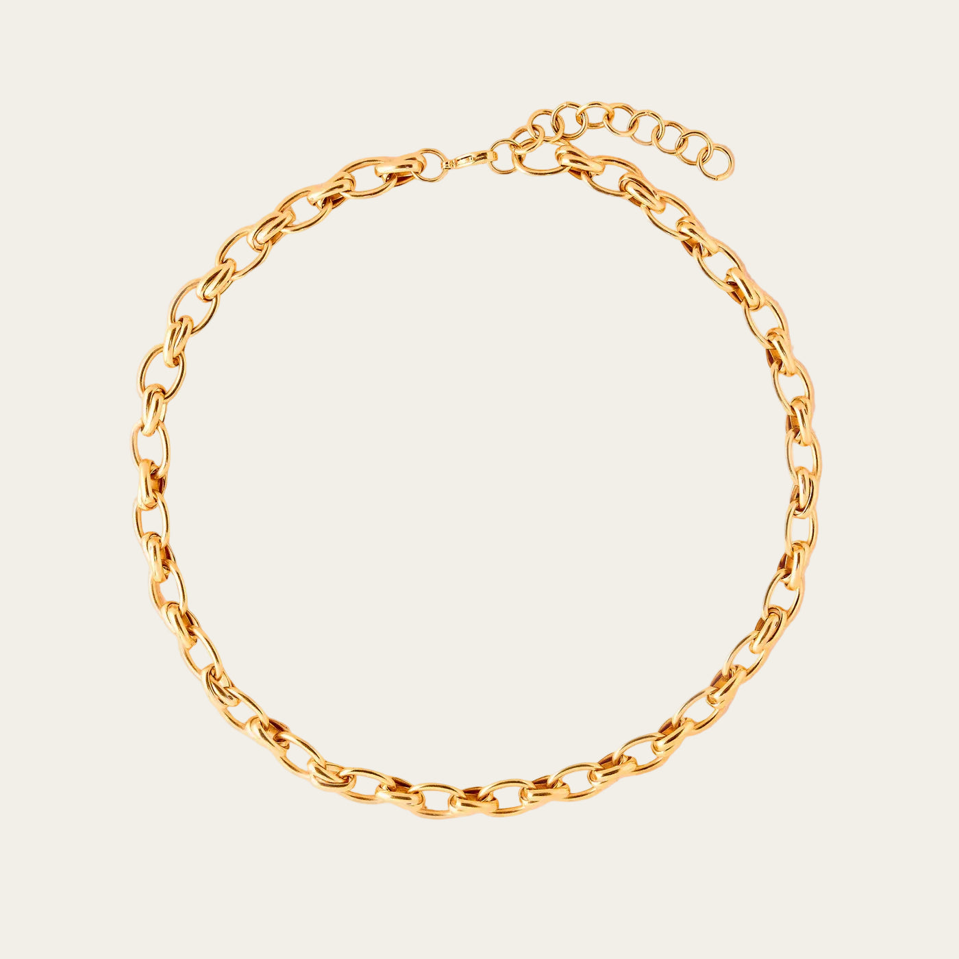Gold chain bracelet on a beige background
