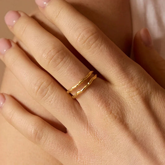 Gold ring on a person's finger with a soft focus background