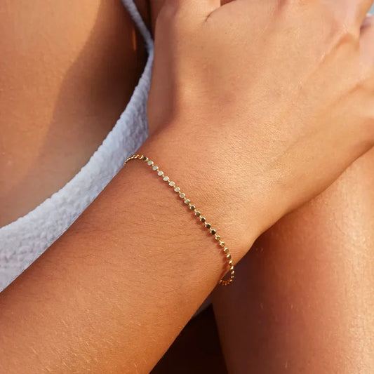 Gold bracelet on a wrist with a blurred background