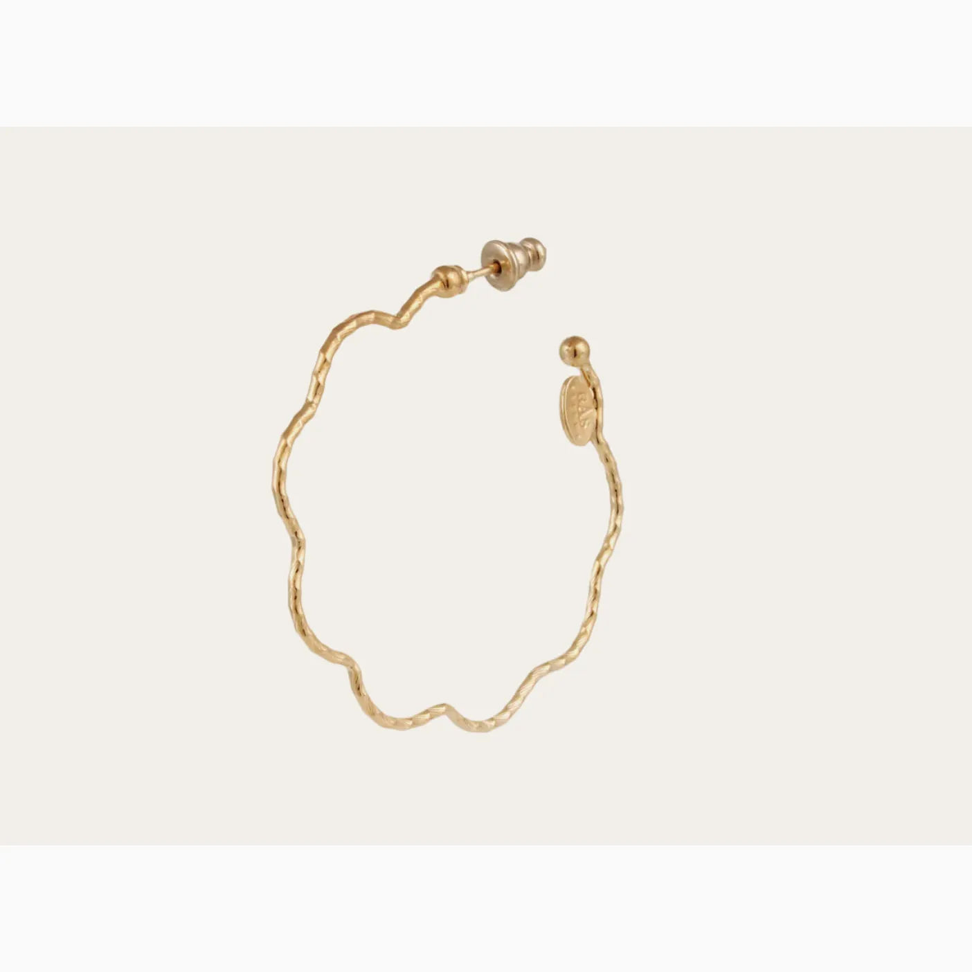 Gold earrings on a beige background