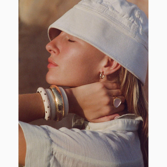 Elevate your style with the Aurélie Bidermann Positano mini hoop earrings, adorned with chic ivory stripes in resin and gilded with 750/1000 yellow gold. These earrings exude timeless elegance and sophistication, perfect for adding a touch of luxury to any ensemble. Total length of buckle: 1.5 cm Diameter of buckle: 1 cm Buckle width: 0.2 cm