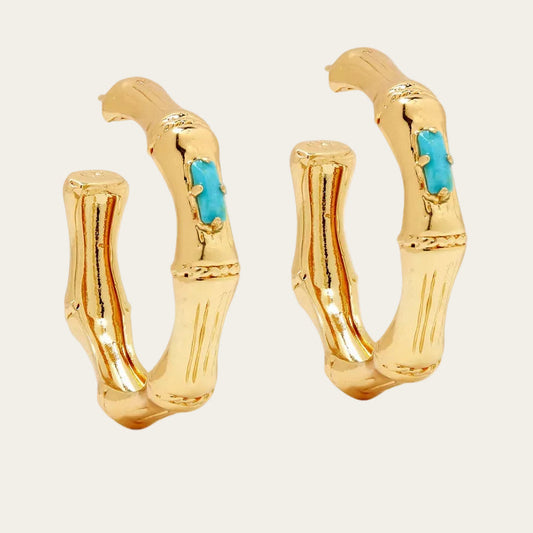 Gold hoop earrings with turquoise stones on a white background