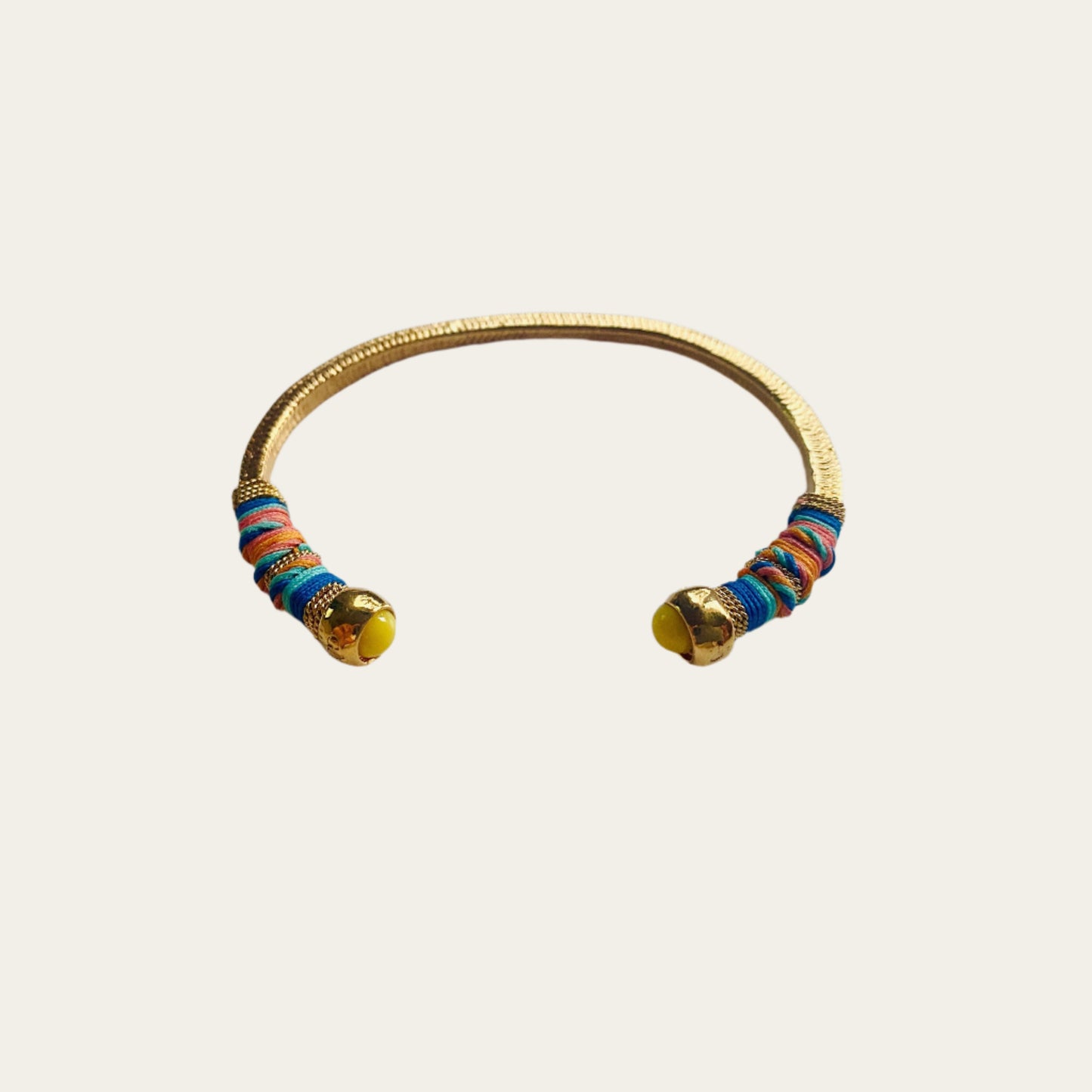 Gold plated bracelet embellished with tinted threads and gold plated chains. The bracelet is adorned with glass beads at ends. Adjustable size. Product Details Yellow Gold Plated Cotton Rope