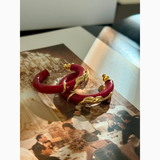 Red bracelet with gold accents on a surface with a blurred background