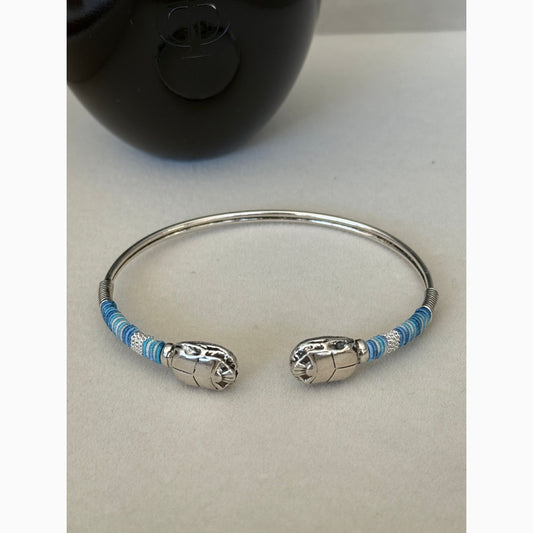 Silver bracelet with blue accents on a light gray background