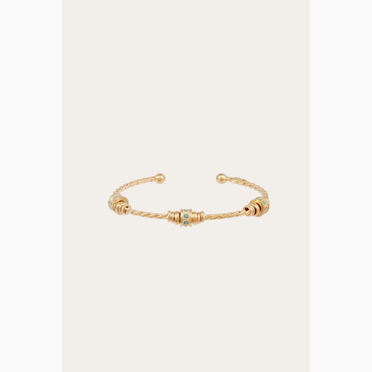 Gold bracelet with small turquoise beads on a white background