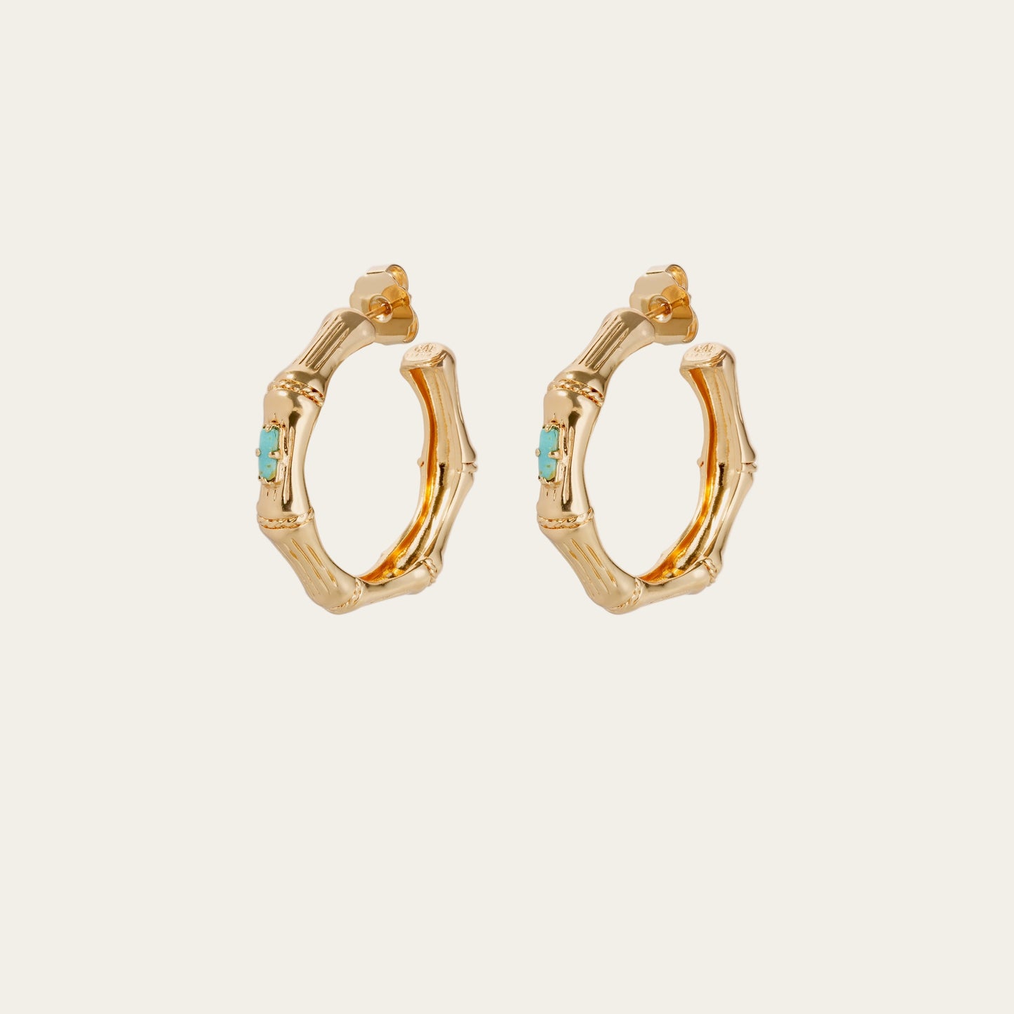 Gold hoop earrings with turquoise stones on a white background