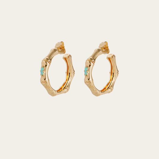 Gold hoop earrings with turquoise stones on a white background