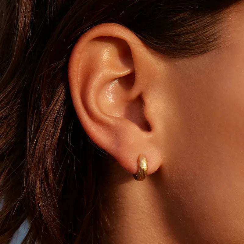 Agapee Anilla mini gold earrings close up on models ear available at The Artemis Edit