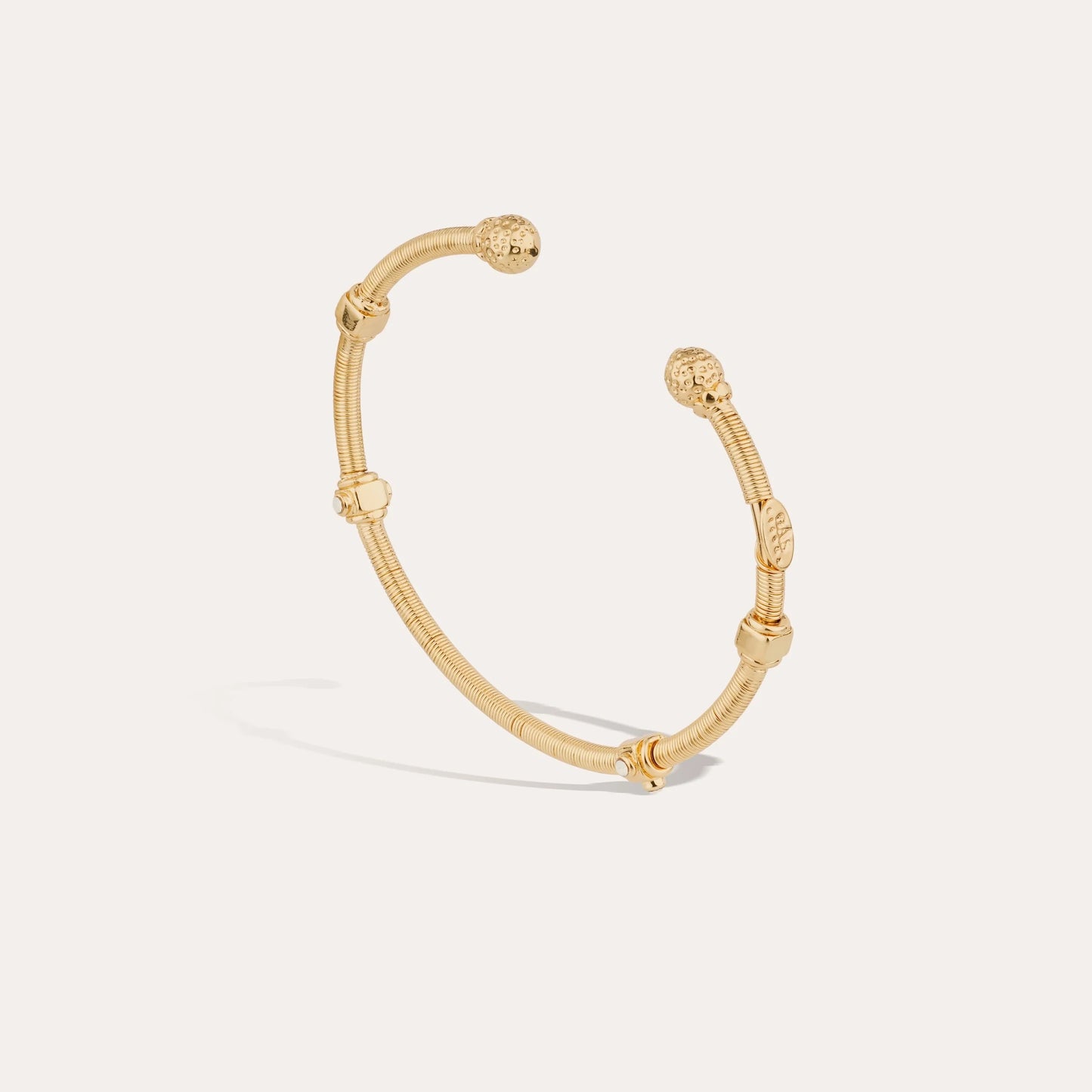 Gold bracelet on a light gray background