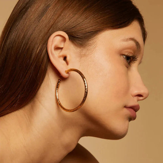 engraved gold hoops on woman with beige background