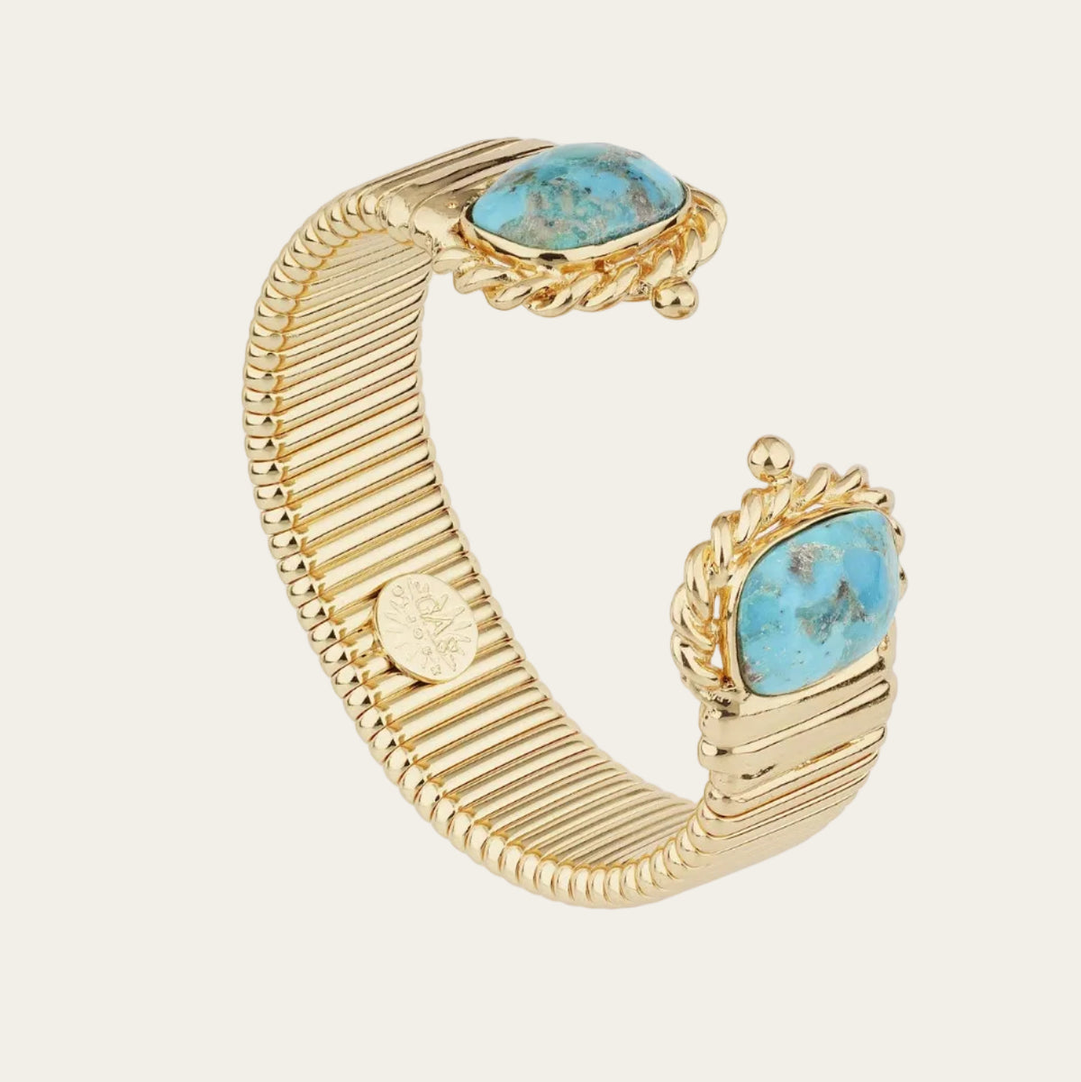 A gold-toned cuff bracelet featuring two oval turquoise stones in ornate settings, displayed on a clean white background.
