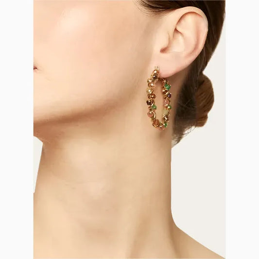 coloured hoop on womans ear neutral background