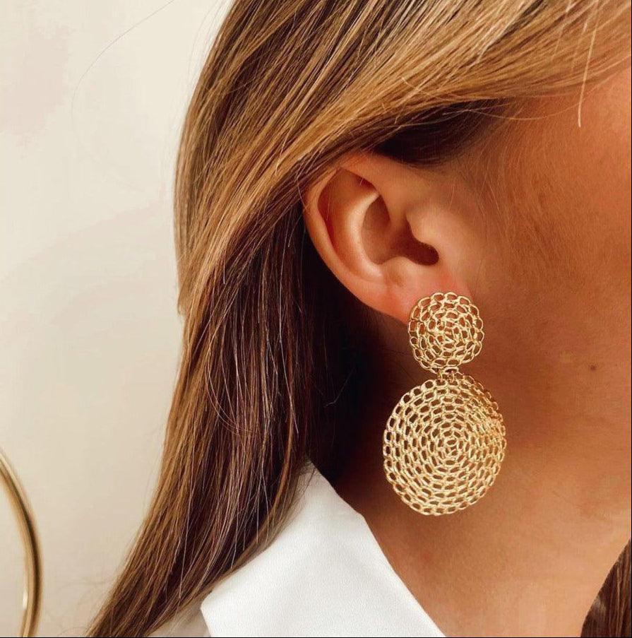 close up of statement gold chain earrings on a woman