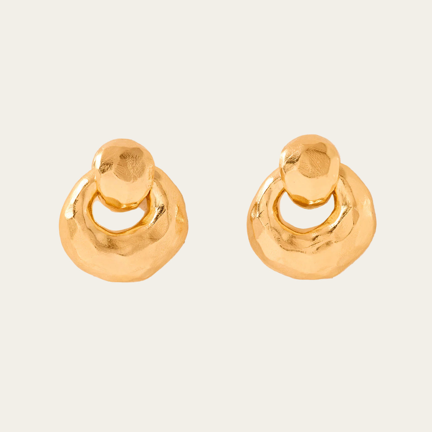 Pair of gold hoop earrings on a beige background