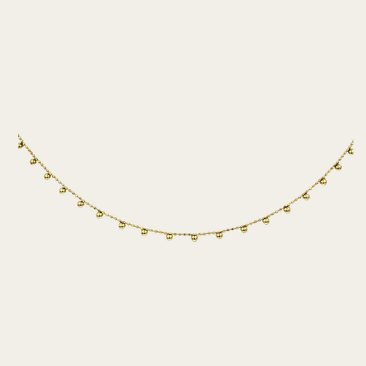 Gold necklace with small beads on a white background