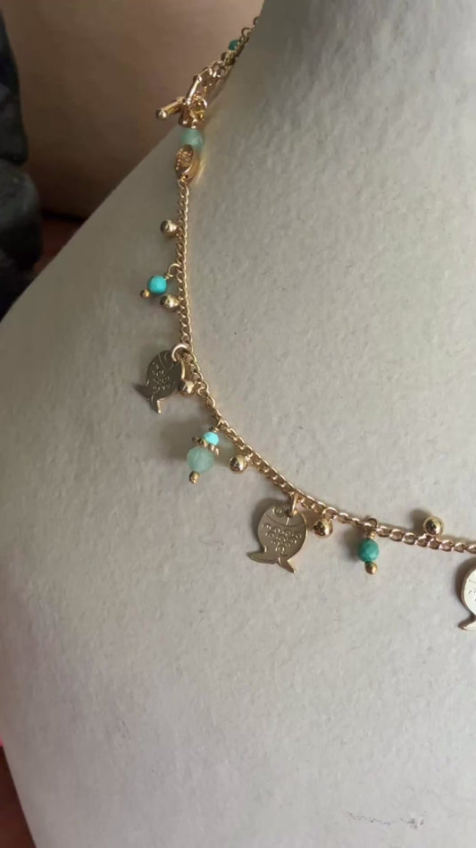 gold necklace with hanging fish and coloured stones