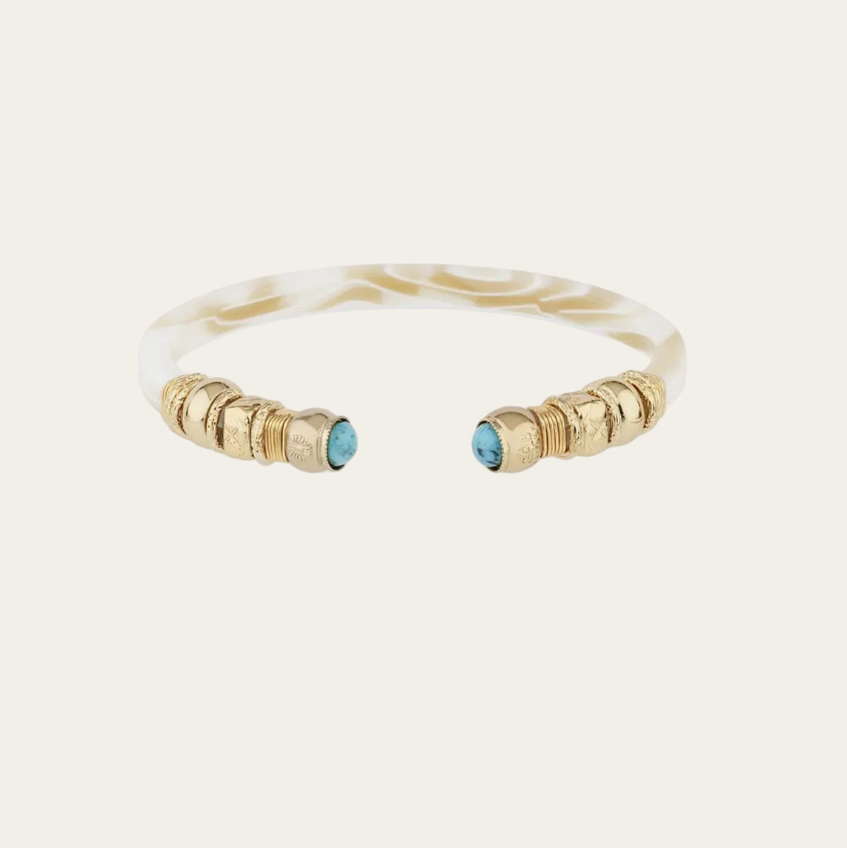 A cuff-style bangle bracelet featuring a white tortoiseshell-patterned band with gold-toned textured beads on each end and small round turquoise blue stones set into the gold caps, shown on a plain white background.