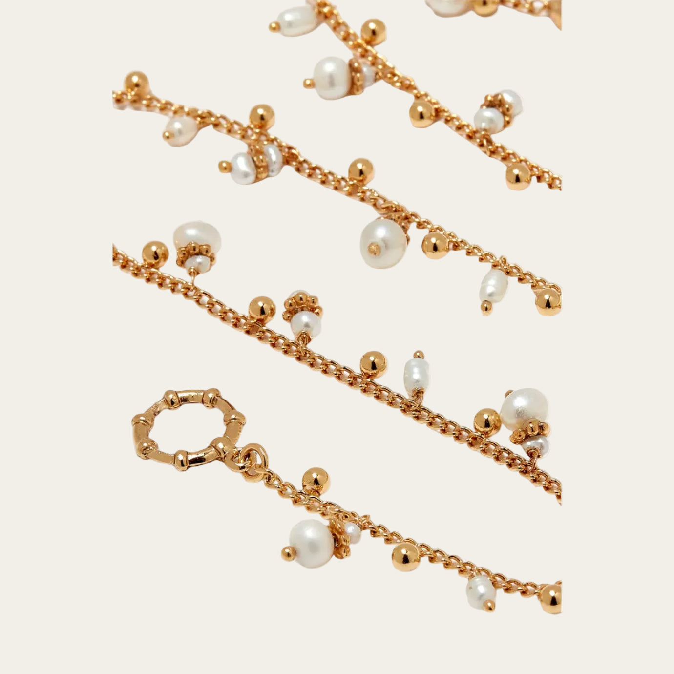 Gold chain necklace with pearls on a white background