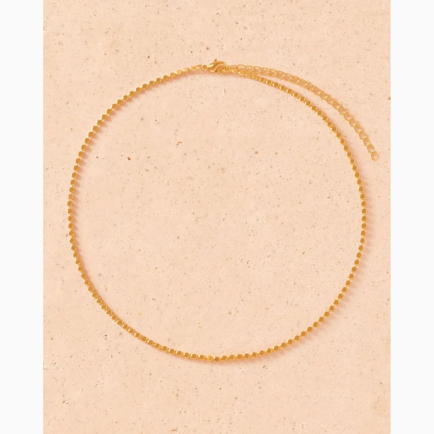 Gold necklace on a beige background