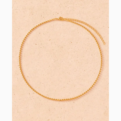 Gold necklace on a beige background