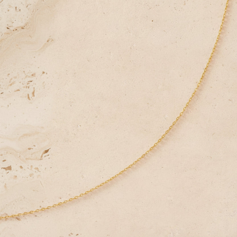 Gold chain on a beige background