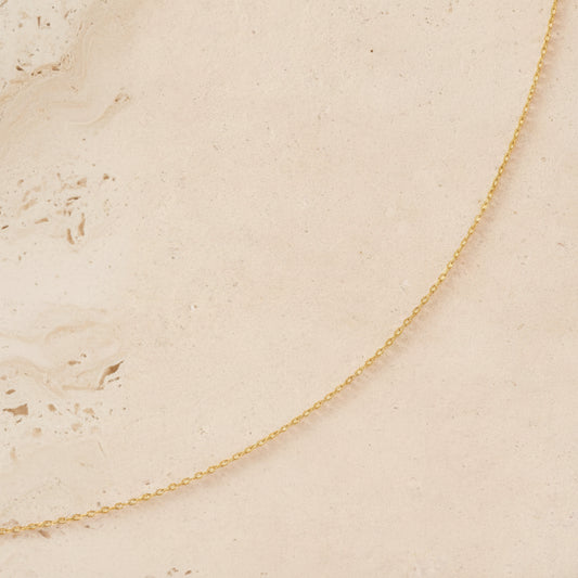 Gold chain on a beige background