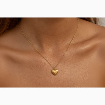 Gold heart-shaped necklace on a person's neck
