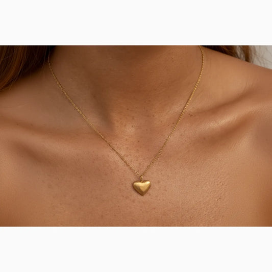 Gold heart-shaped necklace on a person's neck