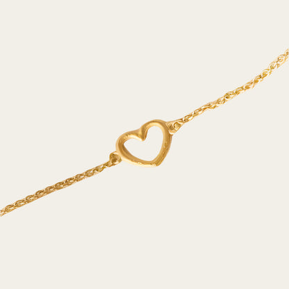 Gold plated chain bracelet with love heart on neutral background
