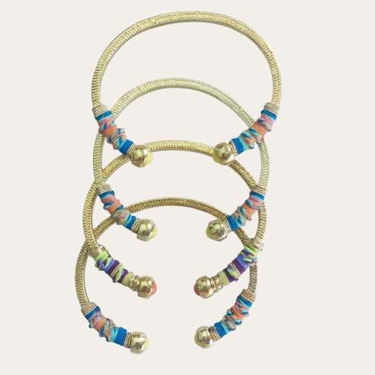 Gold plated bracelets embellished with tinted threads and gold plated chains.  The bracelet is adorned with glass beads at ends. Adjustable size.  Product Details  Yellow Gold Plated Cotton Rope or all metal Width: 0,6 cm; Circumference: 14,5 cm