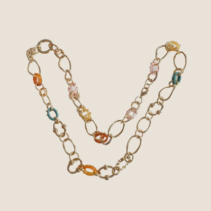Gold plated chain link necklace on flat lay with coloured acetate links in between