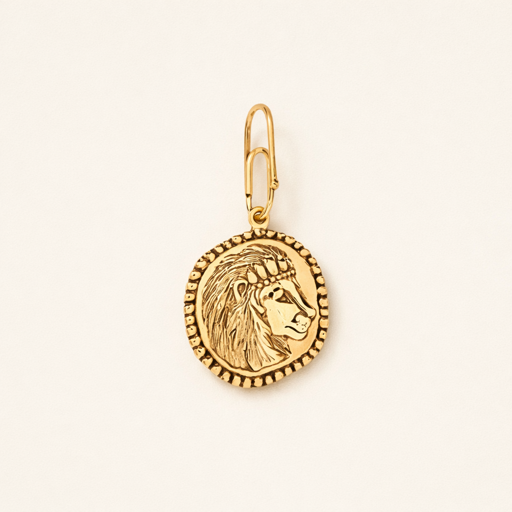 gold intricate lion charm on beige background