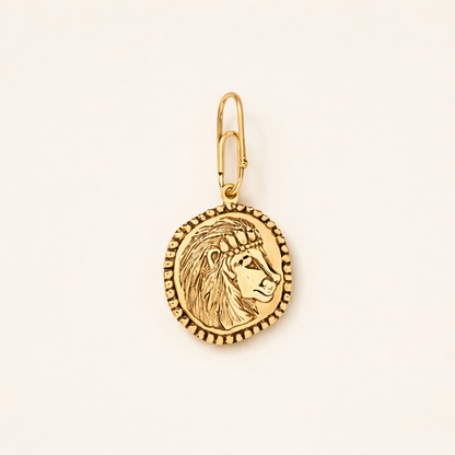gold intricate lion charm on beige background