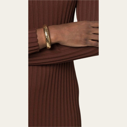 Woman wearing brown dress with gold bangle