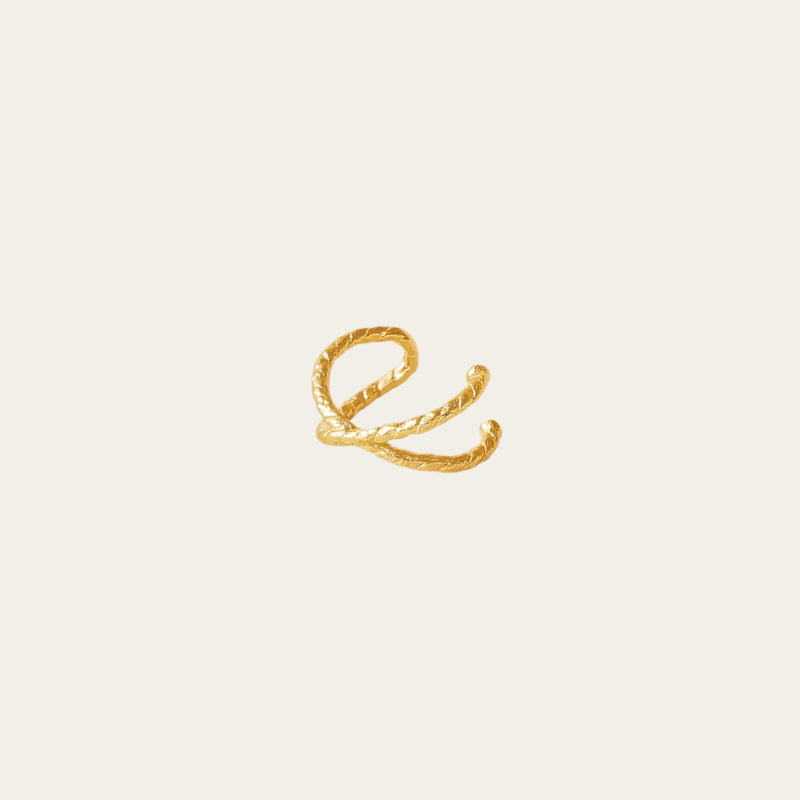 gold gilded earring cuff on being background