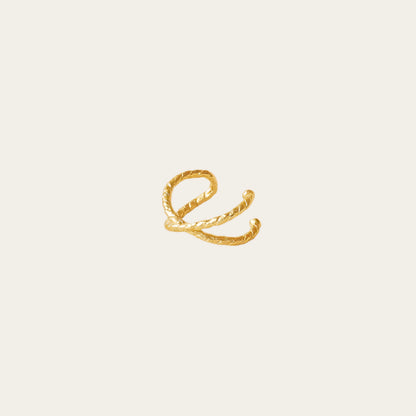 gold gilded earring cuff on being background