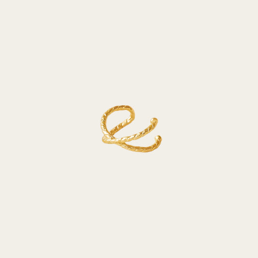 gold gilded earring cuff on being background