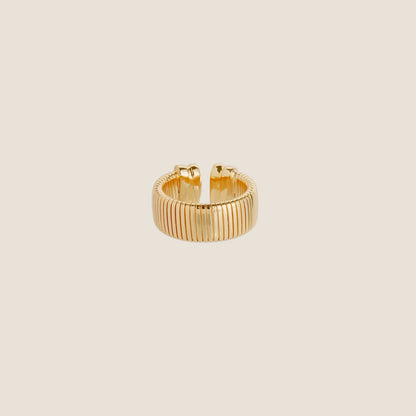 gold ring against plain cream background