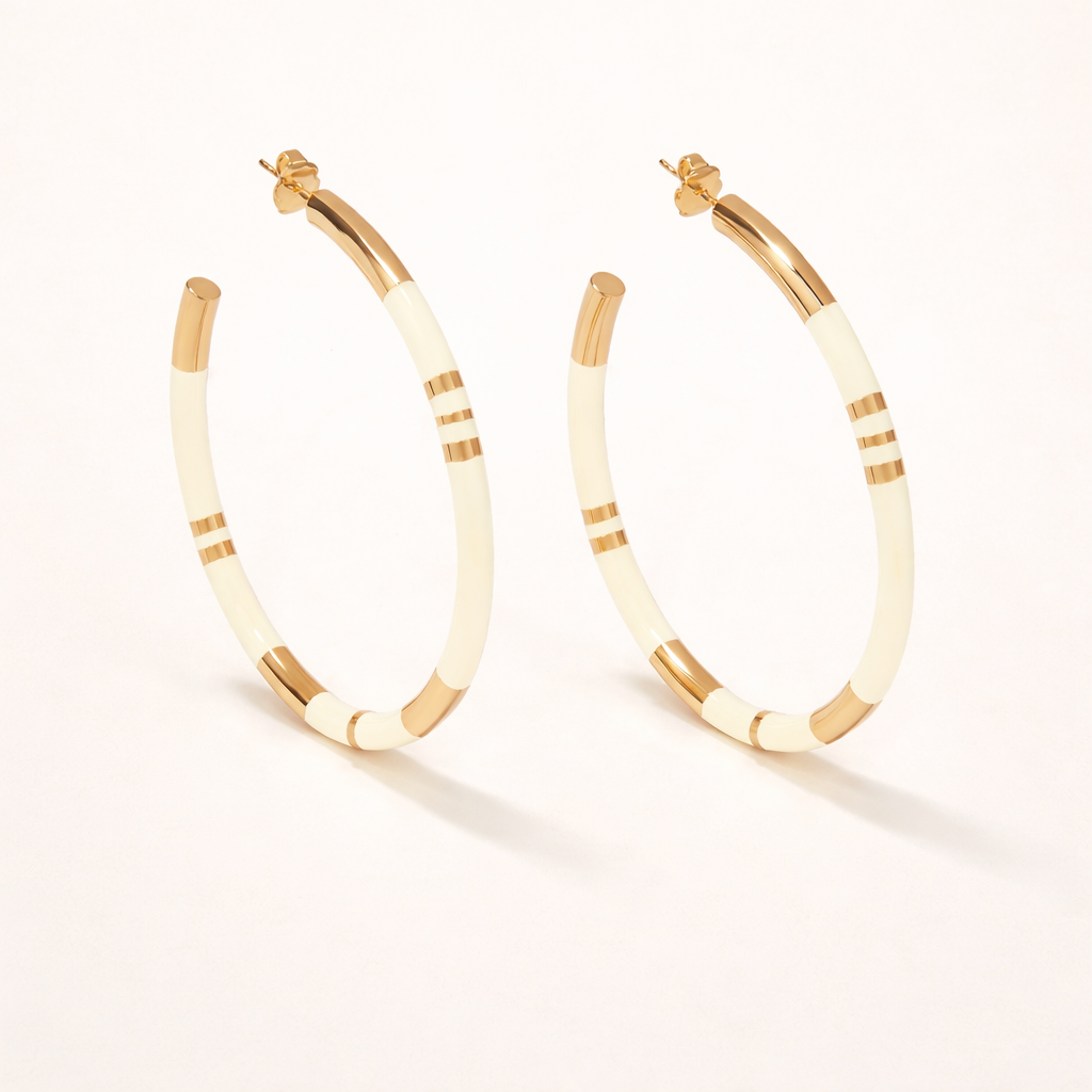 Gold and white hoop earrings on a white background