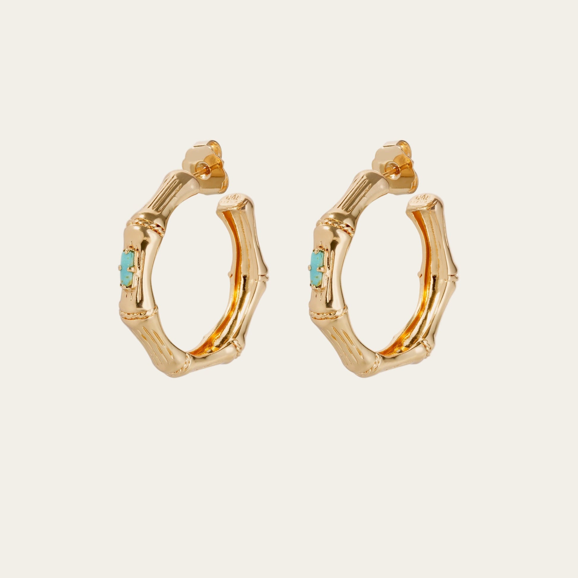 Gold hoop earrings with turquoise stones on a white background